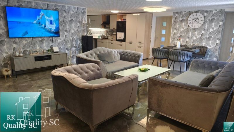 Living room in a family house with comfortable sofas, a TV, and stylish wall decor.