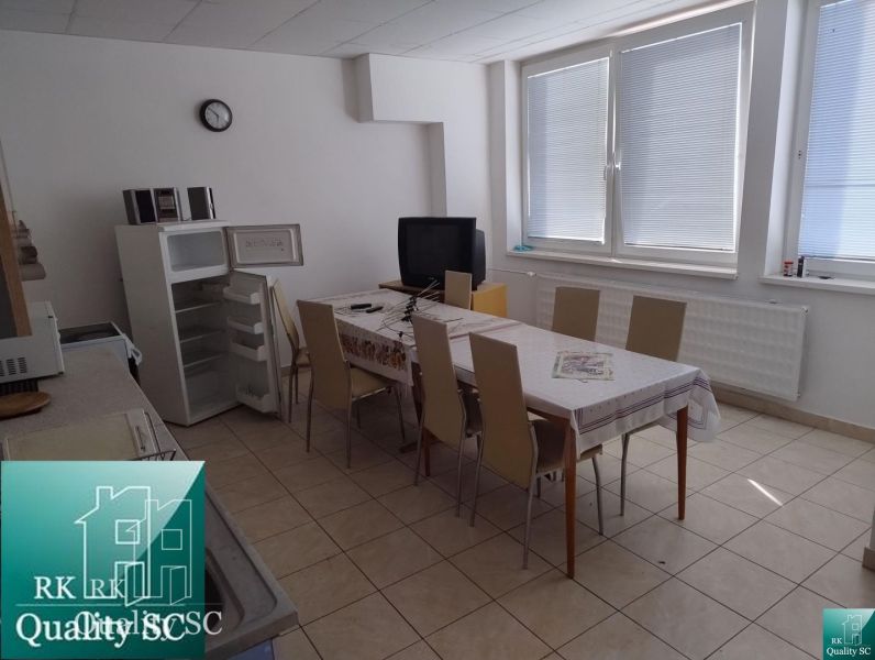 Canteen in the production area with a refrigerator, television, and a table for eight people.