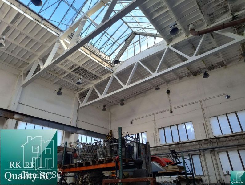 Production spaces with large windows and steel structures under skylights.