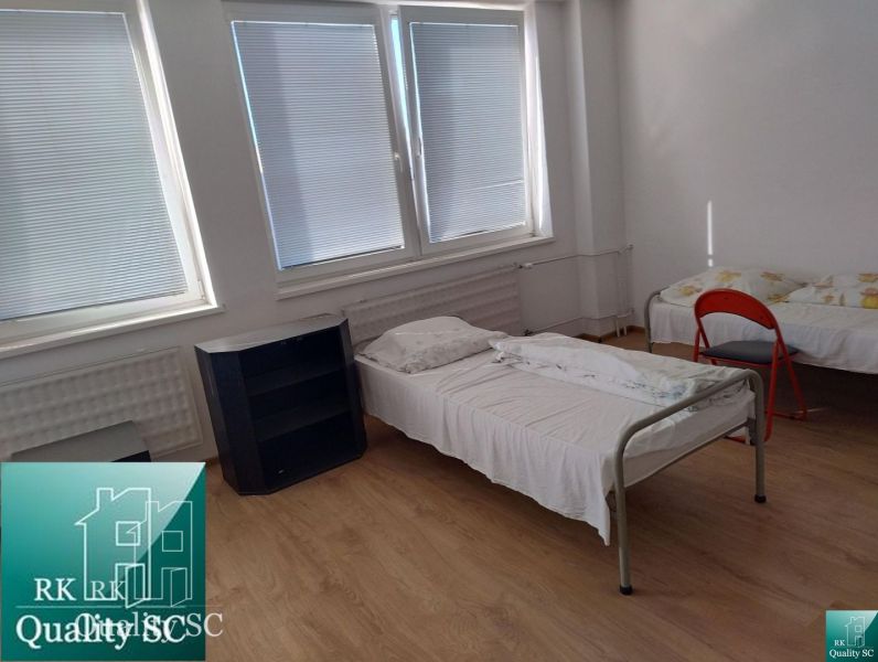 In the production premises, there are two beds, a shelf, and a floor with a wooden decor.