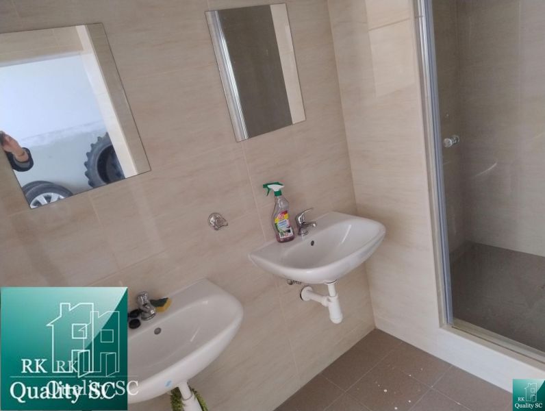 A bathroom with two sinks, mirrors, and a shower in the production facilities.