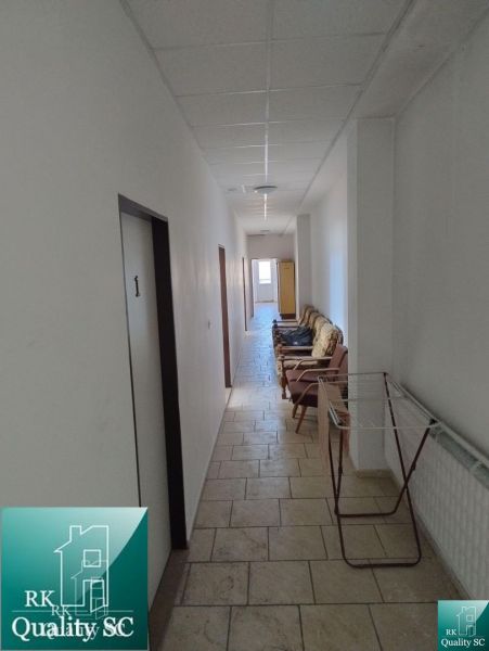 A corridor with chairs in the premises of warehouses and halls, with access to rooms.