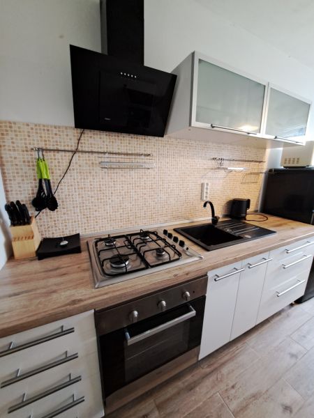A kitchen in a 3-room apartment with a gas stove and a wooden decor floor.