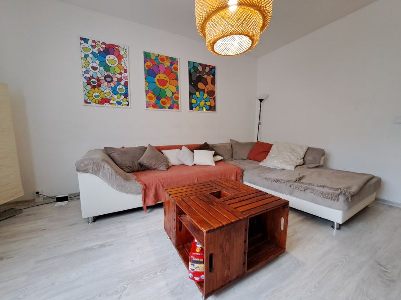 Living room with a sofa and a table made from crates, floor with wood decor, 3-room apartment.