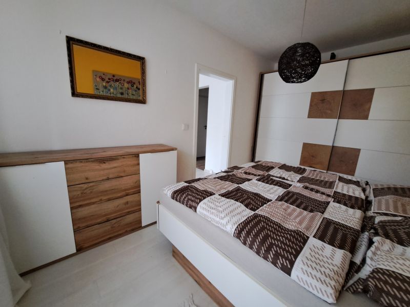 Bedroom in a 3-room apartment with a dresser and a wardrobe, wooden decor flooring.