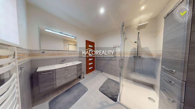 A bathroom in a family house with a modern shower and gray tiles.