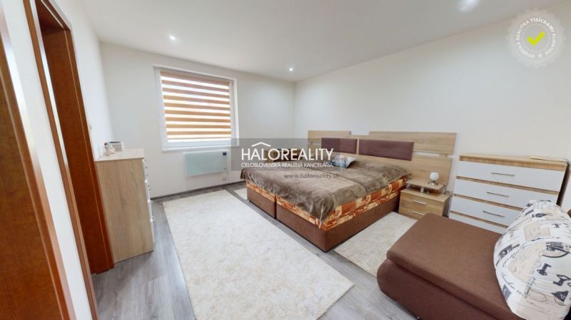 A bedroom in a family house with a wooden decor floor and cozy furnishings.