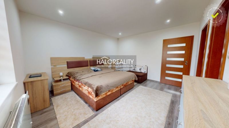 A bedroom in a family house with a wooden decor floor and a comfortable bed.