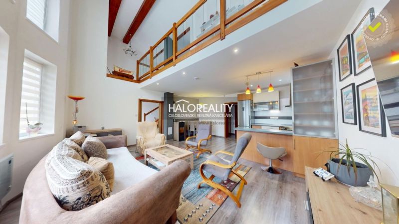 Interior of a family house with a wooden decor floor, open kitchen, and gallery.