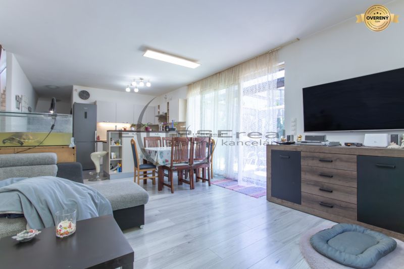 Living room in a family house with a wooden decor floor, sofa, and dining table.