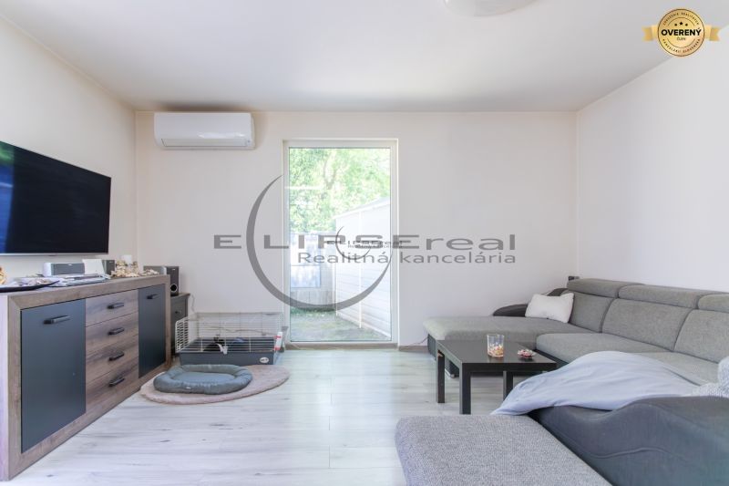Living room in a family house with a gray sofa and a wooden decor floor.