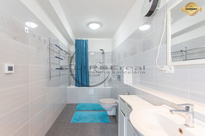 A bathroom in a family house with a bathtub and blue accessories.