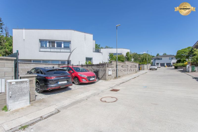 A street with family houses in Stupava, parked cars, clear weather.