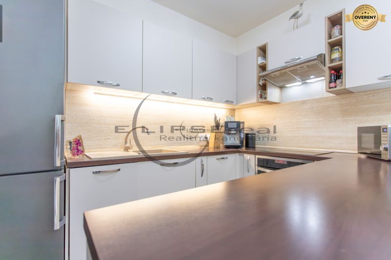 A kitchen with furniture, appliances, and wooden decor in a family house.