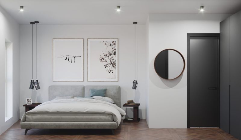Bedroom in a 3-room apartment with a bed, mirror, and wooden decor flooring.