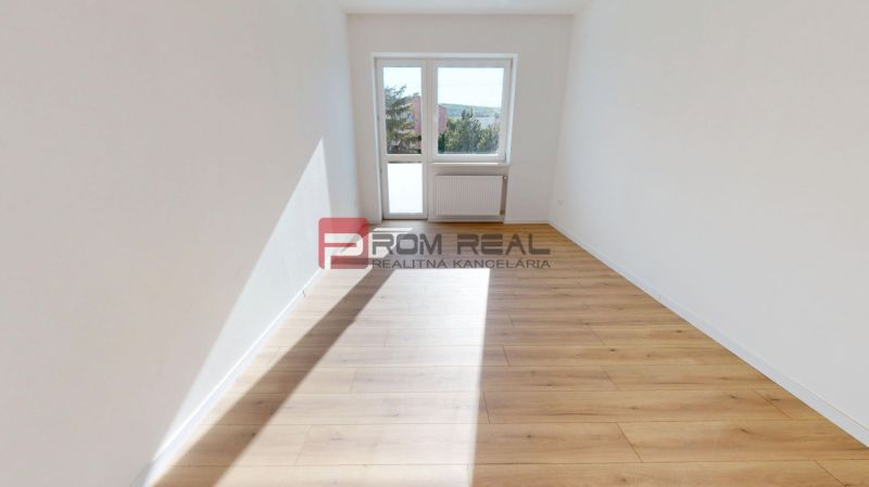 A bright room with white walls and a wooden decor floor in a family house.