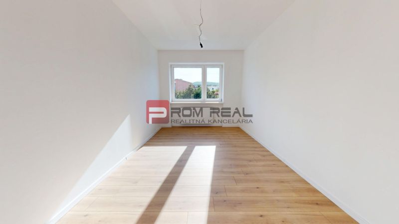 A bright room with white walls and wood-decorated floors in a family house.