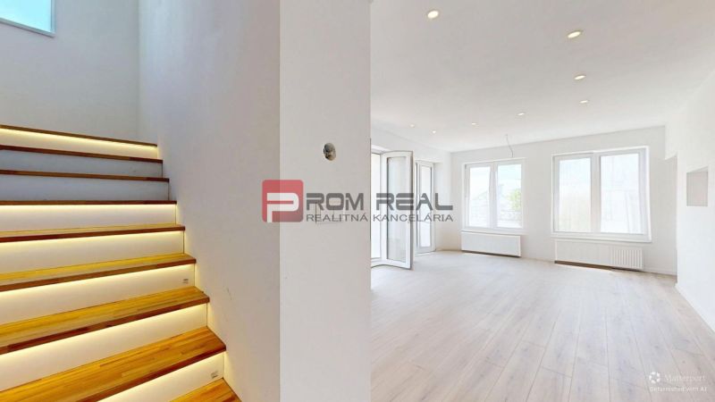 Interior of a family house with illuminated staircase and wooden decor flooring.