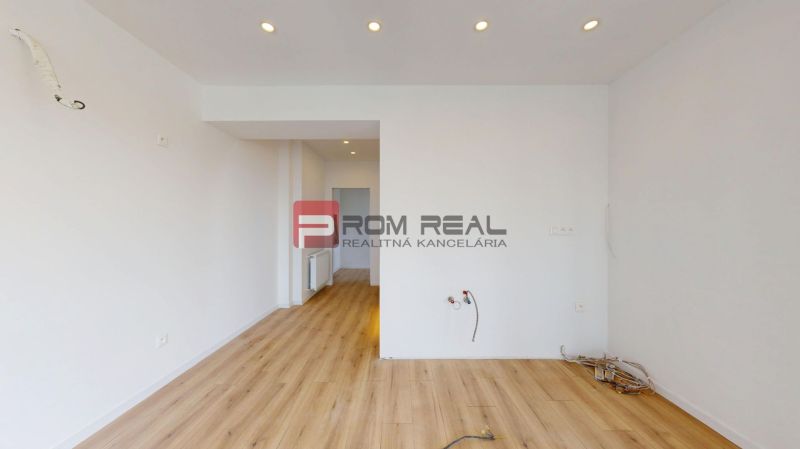 The interior of a family house with white walls, a floor with a wooden decor, ready for installation.