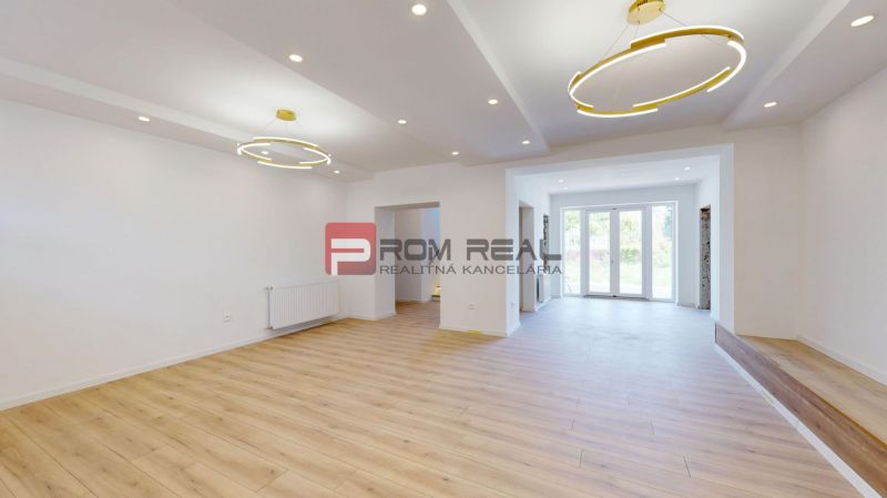 Living room in a family house with large windows and a wooden decor floor.