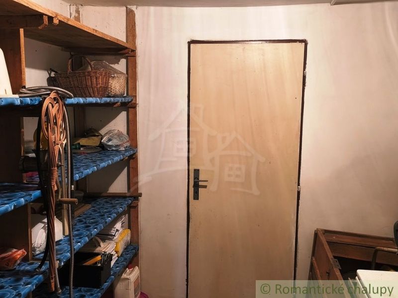 Shelves and doors in the basement area of the cabin with stored items.