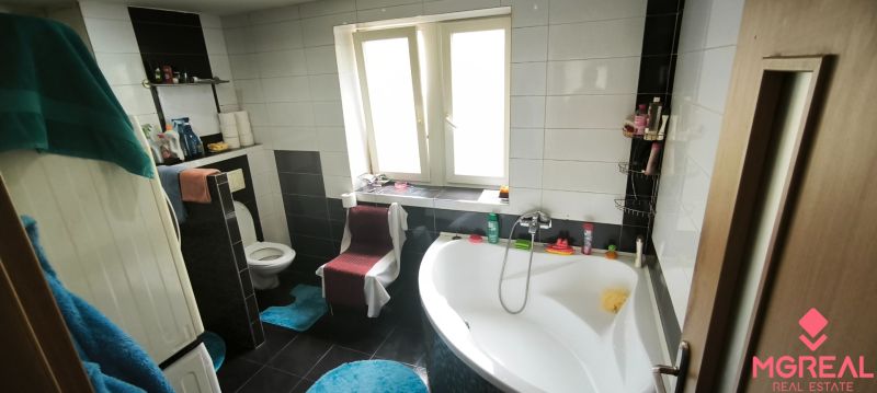 Bathroom with a bathtub and toilet in a 3-room apartment, tiles on the walls.