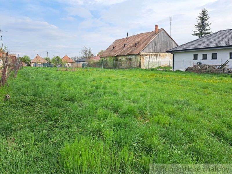 Family houses in Hruboňovo surrounded by green gardens and blue skies.