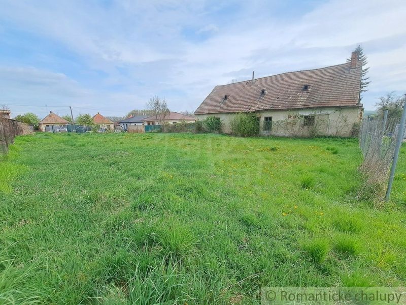 An older house surrounded by a grassy plot in the gardens of Hruboňovo.