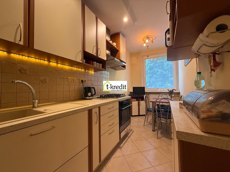 A kitchen in a 3-room apartment with LED lighting and a dining area.