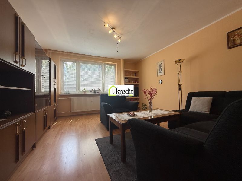Living room in a 3-room apartment with a wooden decor floor and a comfortable sofa set.