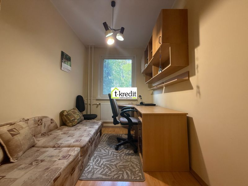 A workspace in a 3-room apartment with a sofa and a table with a shelf.