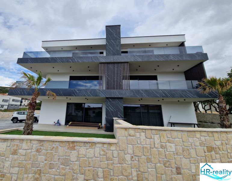 A recreational apartment in Stara Novalja with modern architecture and a subtropical garden.