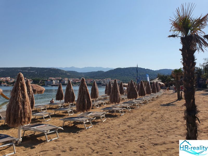 Sandy beach with loungers and umbrellas in Stara Novalja near the holiday apartment.