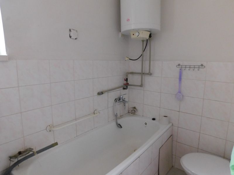 Bathroom with a bathtub, boiler, and toilet in a family house.