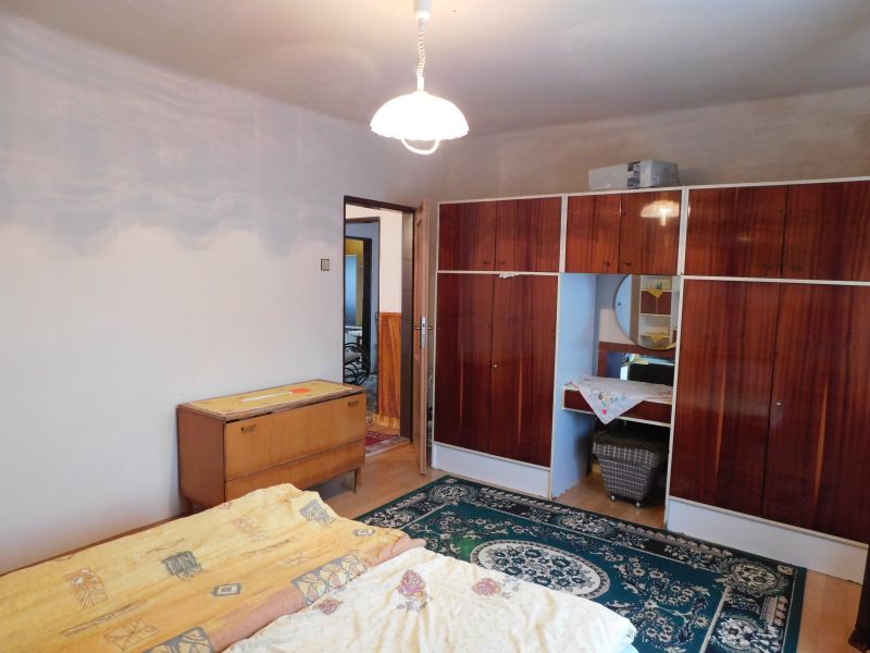 A bedroom in a family house with carpets and antique furniture.