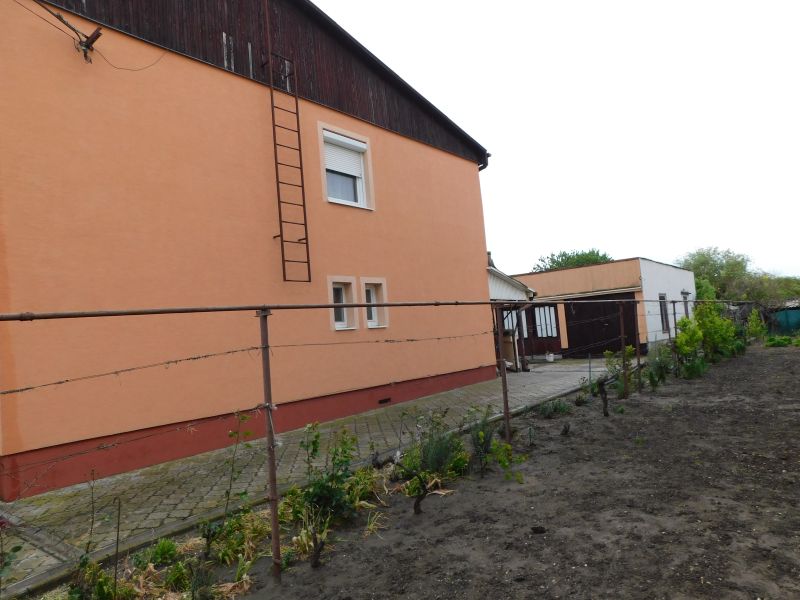 A family house in Dvory nad Žitavou with an orange facade and an adjacent garden.