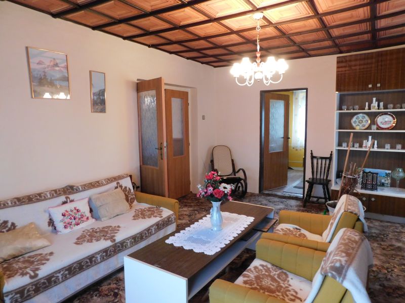 Living room in a family house with flowers and a patterned carpet.