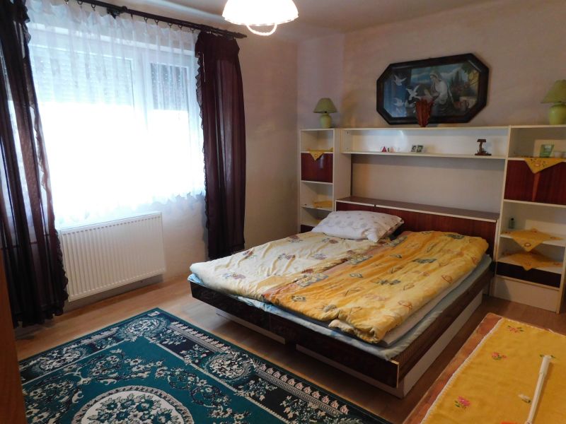A bedroom in a family house with carpets and a wooden decor floor.
