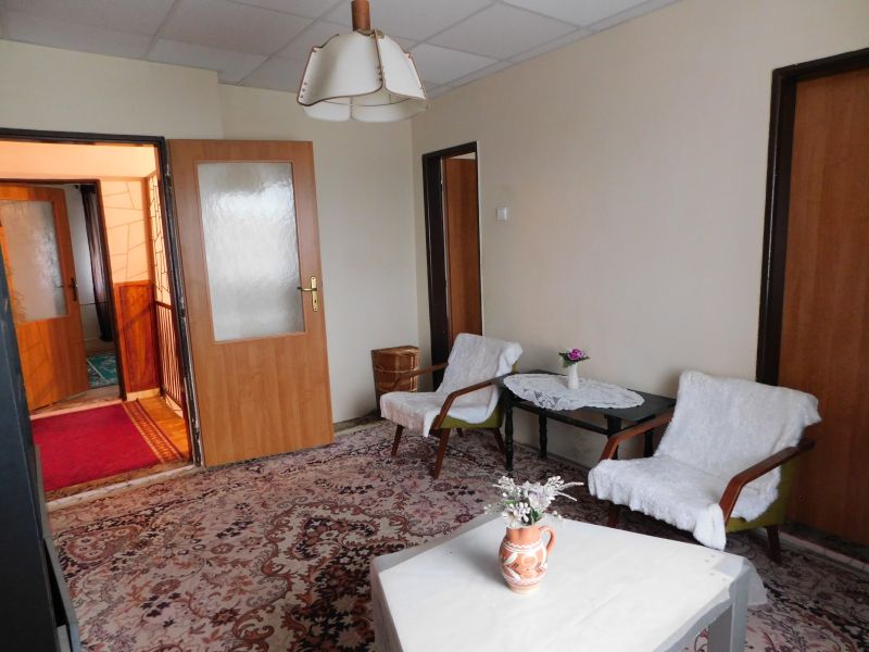 Living room in a family house with upholstered chairs and a decorative carpet.