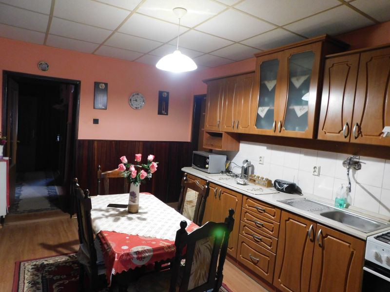 A kitchen with wooden decor, a dining table, and cabinets in a family house.