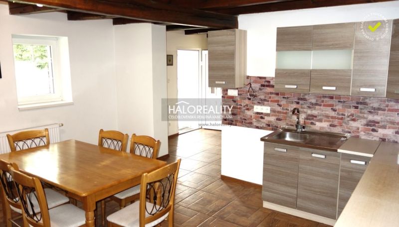 A kitchen in a family house with natural decor, brick cladding, and a wooden decor floor.