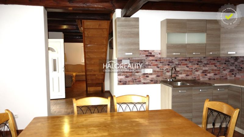 A kitchen with a wooden decor floor in a family house, wooden ceiling, brick wall cladding.
