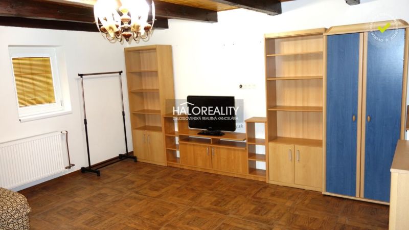 Living room with shelves, television, and wooden decor flooring in a family house.