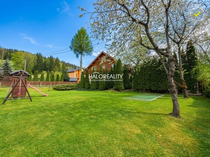 A garden with a lawn, playground, and trees in hotels and guesthouses in Makov.