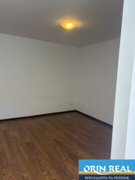 A room in a one-bedroom apartment with a floor featuring a wood decor.