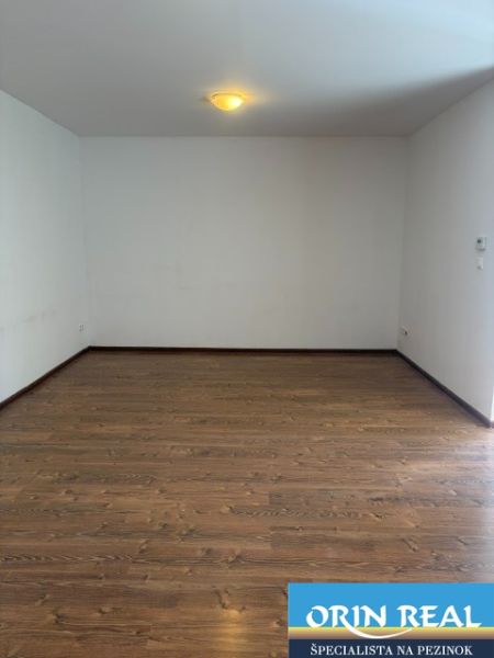 A room with a wooden decor floor in a studio apartment.