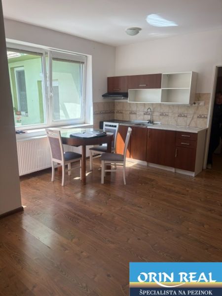 1-bedroom apartment with a kitchen and dining table, wooden decor flooring.