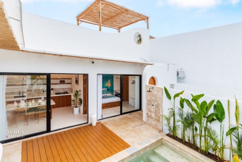 Villa in Bali with a wooden decor floor by the pool and an outdoor shower.
