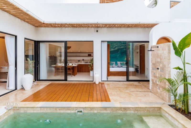 Villa in Bali with a pool, wooden decor flooring, and open design.