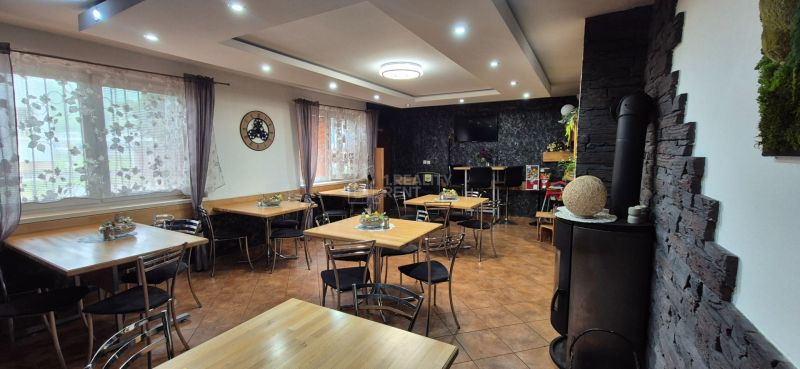 Commercial spaces with tables, chairs, and decorative curtains, with a wooden decor floor.